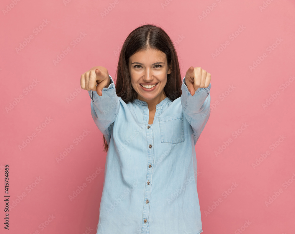 casual woman pointing at the camera with both hands casual woman pointing at the camera with both hands