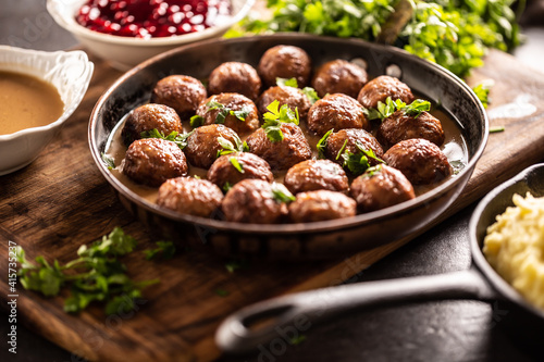 Swedish meatballs, kottbullar, in a pan topped with fresh parsley photo