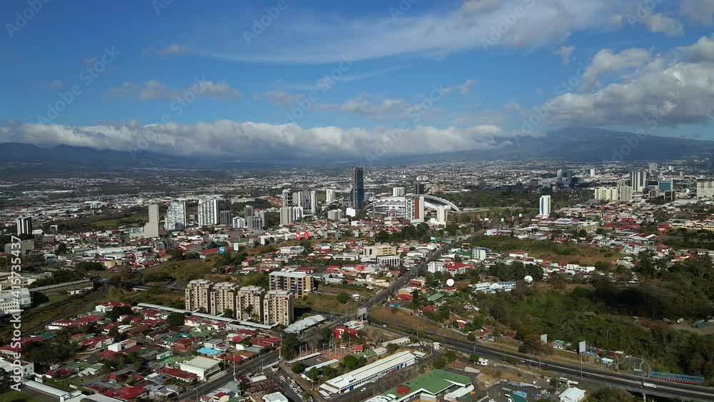 Beautiful cinematic aerial view of the city of San Jose  Costa Rica with view of the Sabana Park, and Churches 