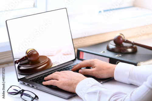 . Jurisprudence courses. On the table there is a computer and a folder with business papers. Online learning