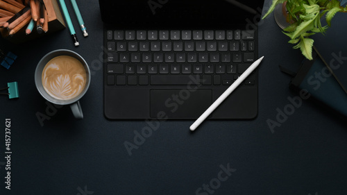 Fotografie, Tablou Overhead shot of wireless keyboard, stylus pen, coffee cup and plant on modern dark workplace