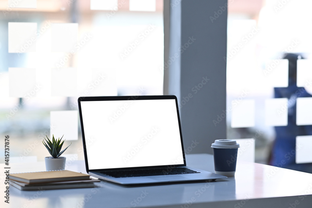 Computer laptop with blank screen , notebook, coffee cup and plant on white table. Computer laptop with blank screen , notebook, coffee cup and plant on white table.