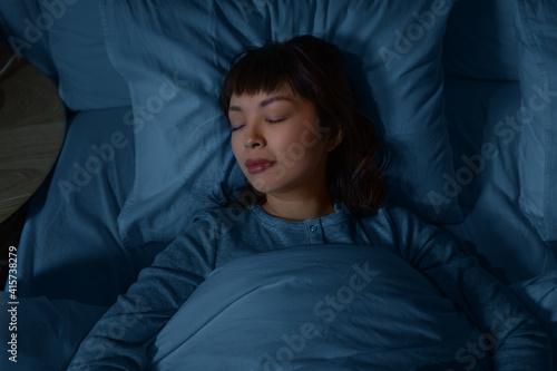 people, relax and comfort concept - young asian woman sleeping in bed at home at night