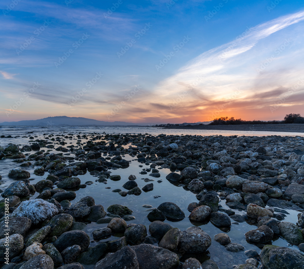 colorful sunset on the Mediterranean Sea in Almeria with rocks and tidal pools in the foreground