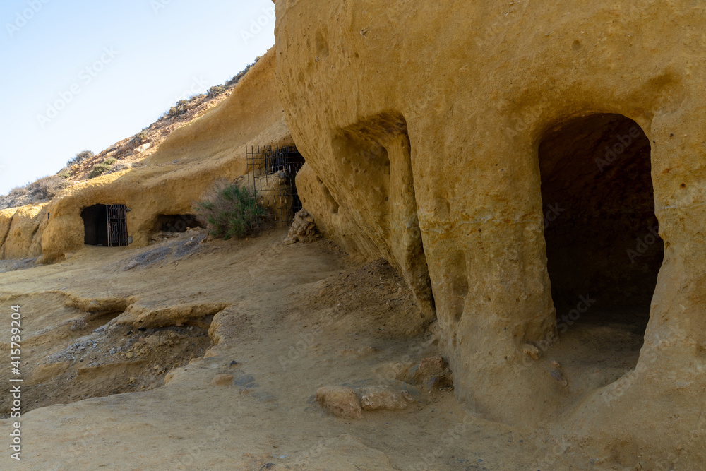 sandstone caves and dwellings at an idyllic cove and beach on the coast o Murcia