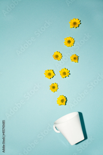 good morning mood. White cup with yellow flowers on a blue background photo