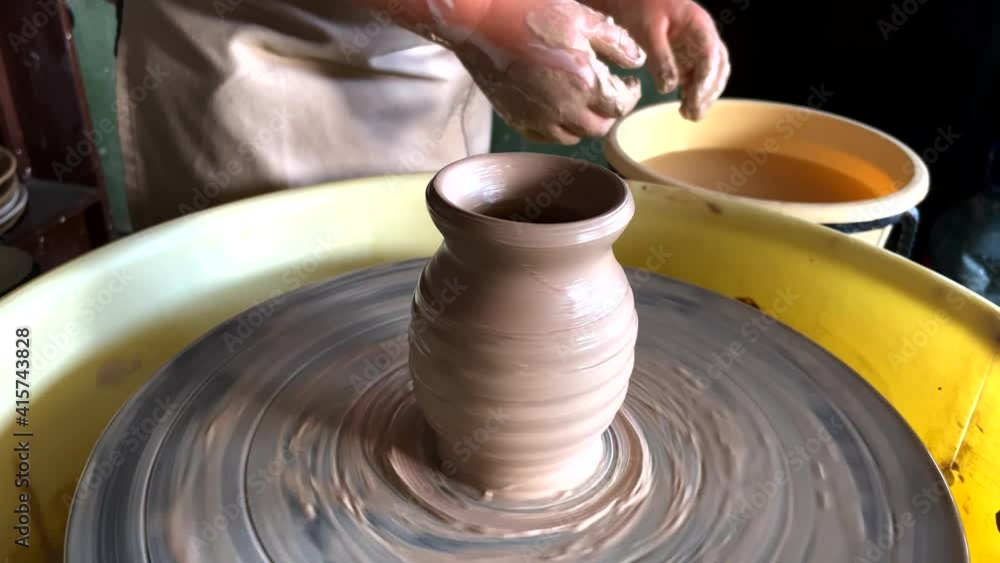 Child hands sculpt earthenware jug on pottery wheel. Child hands sculpt earthenware jug on pottery wheel.