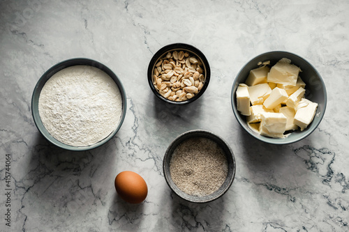 Ingredients for baking cookies. Flour, sugar, vanilla, salt, butter, peanut, egg. Top view horizontal photo, marble backdrop