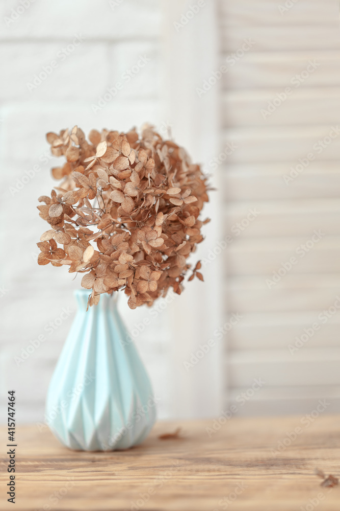 Dried flowers hydrangea in a blue vase on wooden table and white background. Dried flowers hydrangea in a blue vase on wooden table and white background.