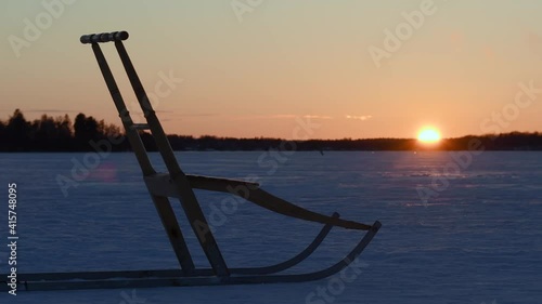Beautiful winter landscape during sunset and a kick sled, also known as snow kick, in retro wooden material. Footage made in Sweden.