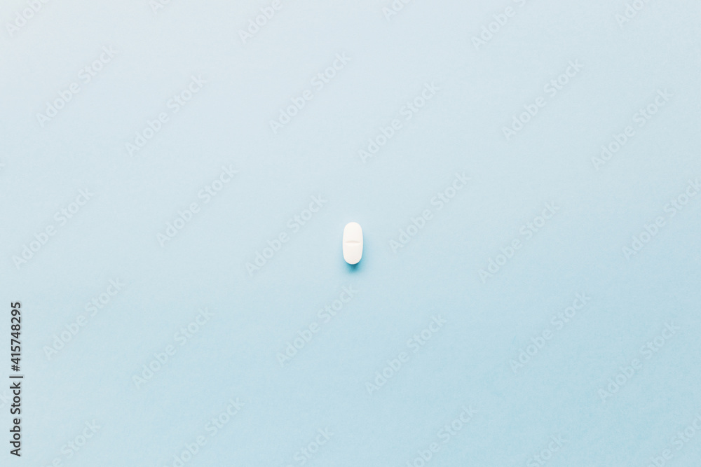 a medical treatment pill on blue background. Space for text