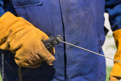 Profession welder, working specialty, equipment tool for welding metals electrode holder in the hands of a man at work, employment and labor