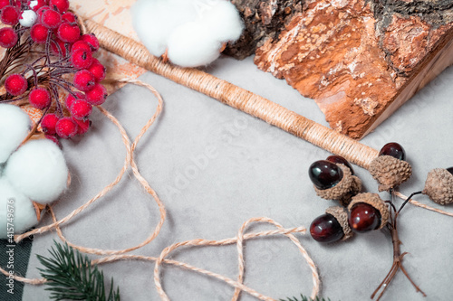 The background is made of gray fabric, wood, rope. acorn, cotton, and berries