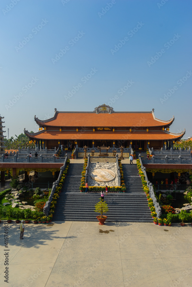 Fototapeta premium Beautiful traditional decorations and details on the roof of the temple at Vinh Nghiem monastery with many visitor in Ho Chi Minh city, Vietnam