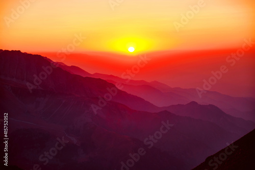 Majestic mountain landscape with silhouettes of mountain ridges at sunset