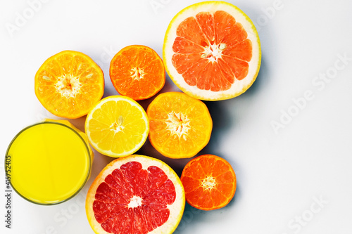Sliced citrus on a white background with a glass of fresh juice. Grapefruit  lemon  tangerine