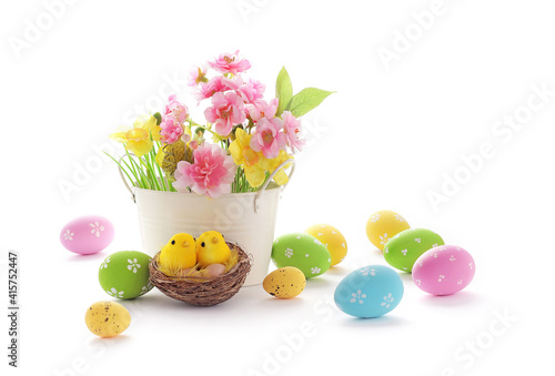 basket with colorful easter eggs and spring flowers isolated on white background