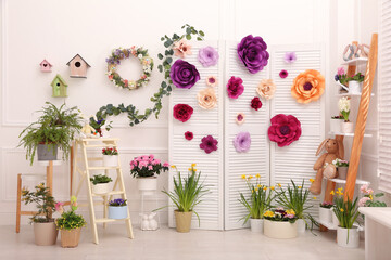 Easter photo zone with plants and paper flowers indoors