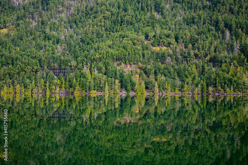 reflection of train bridge on a tranquil lake at Cameron Lake  BC  Canada