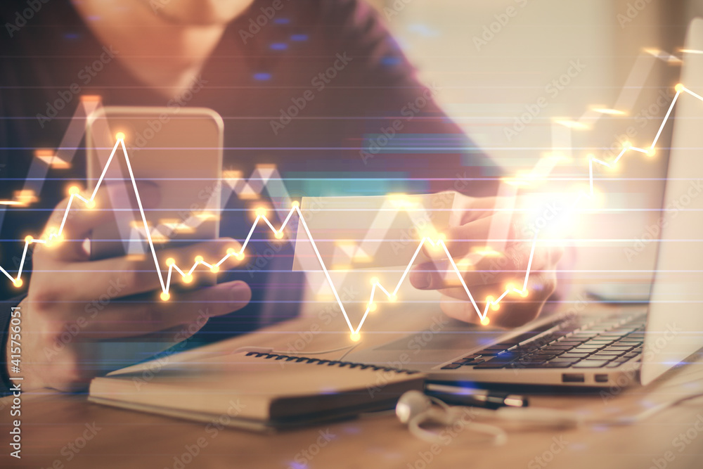 Double exposure of man's hands holding and using a phone and financial graph drawing. Analysis concept. Double exposure of man's hands holding and using a phone and financial graph drawing. Analysis concept.