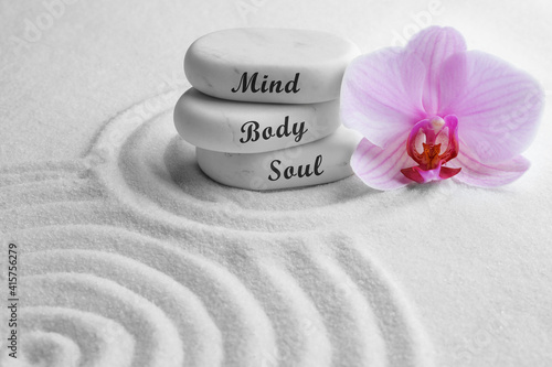 Stones with words Mind, Body, Soul and orchid on sand. Zen lifestyle photo