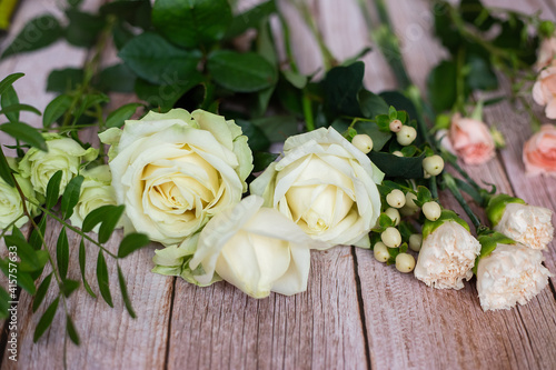 Close-up of different pastel roses in a bouquet on the table at the florist