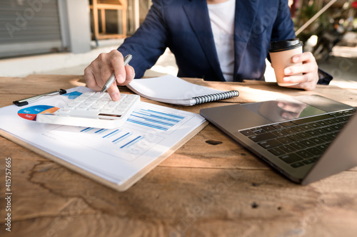 businessman working on desk office with using a calculator to calculate the numbers, finance accounting concept