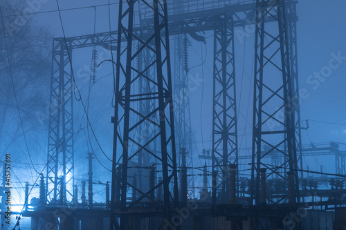 high voltage industrial power plant at night in fog