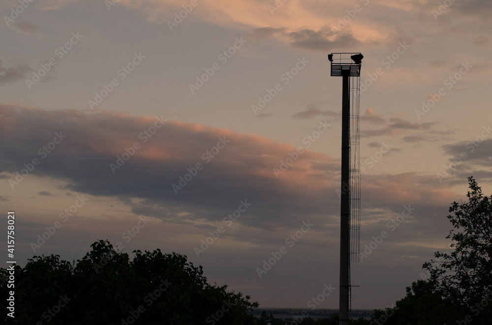 A solitary pillar against the backdrop of clouds illuminated by the sunset A solitary pillar against the backdrop of clouds illuminated by the sunset