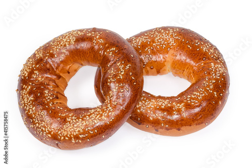 Ring shaped bread rolls sprinkled with sesame on white background