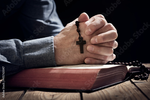 Photography Praying hands on a Holy Bible with religious cross and rosary beads