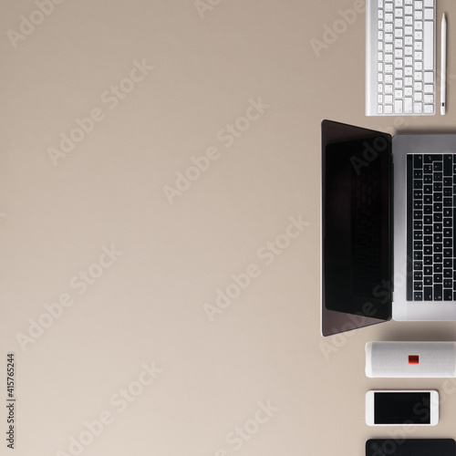Flat lay top view office desk working space with laptop and office supplies on brown background.