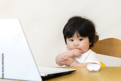 ノートパソコンを使う赤ちゃん。デジタルネイティブ世代イメージ（0歳、生後7カ月、女の子、日本人）