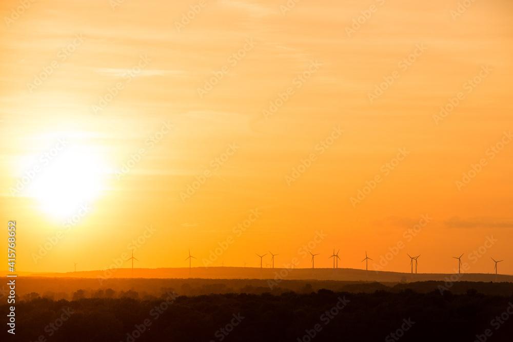 Eco power. Wind turbines with sun background Eco power. Wind turbines with sun background