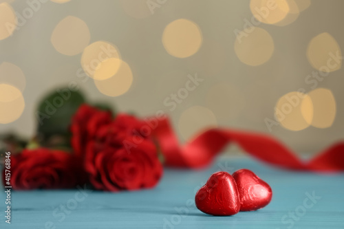 Heart shaped chocolate candies on light blue table  space for text. Valentines s day celebration