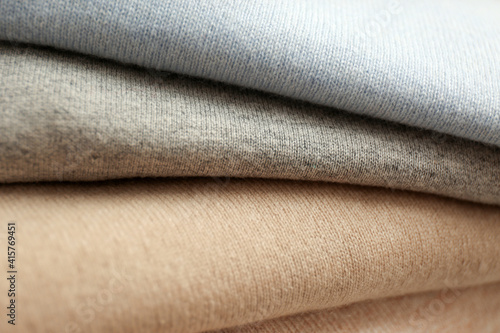 Stack of cashmere clothes as background, closeup