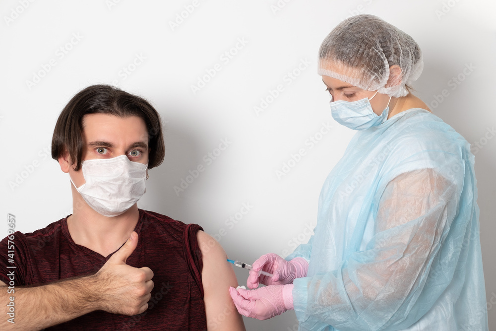 Woman doctor, a nurse makes an injection of a vaccine, a vaccination to a patient.