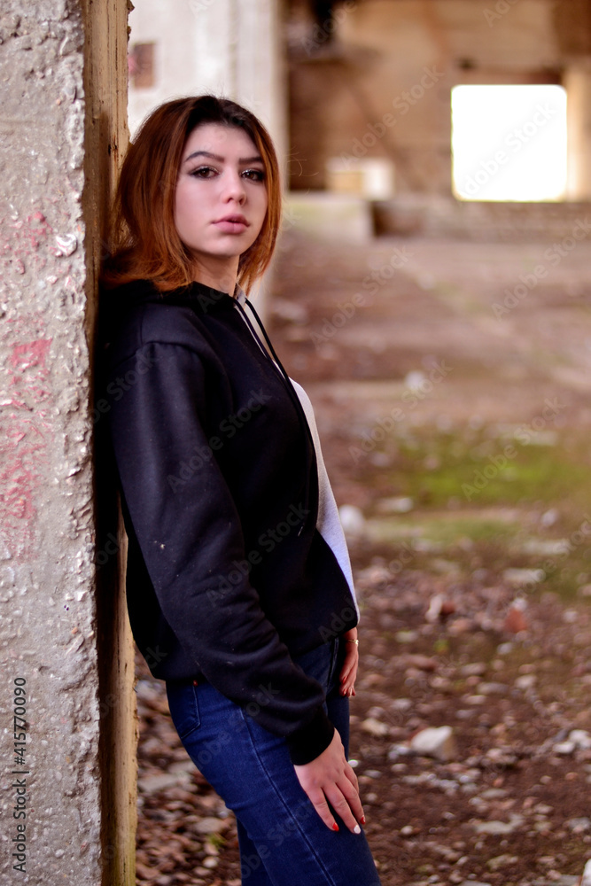 Young red-haired girl in a tracksuit in an abandoned building Young red-haired girl in a tracksuit in an abandoned building
