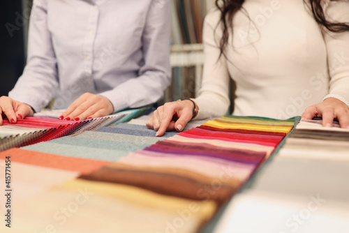 Designer and client choosing fabric in catalog closeup