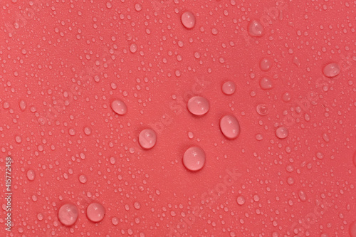 Water drops on red background texture. backdrop glass covered with drops of water. bubbles in water