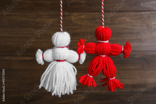 Traditional martisor shaped as man and woman on wooden background. Beginning of spring celebration