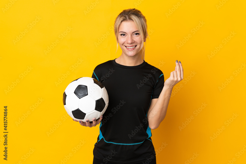 Young Russian football player woman isolated on yellow background making money gesture Young Russian football player woman isolated on yellow background making money gesture
