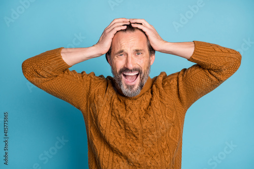 Photo portrait of middle-aged bearded man amazed shocked keeping head with hands shouting isolated on vibrant blue color background photo