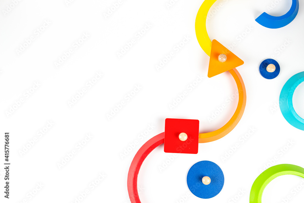 Wooden geometric shapes colorful toy figures composition on white background. Top view Wooden geometric shapes colorful toy figures composition on white background. Top view