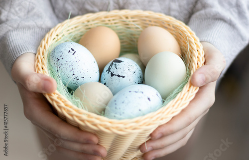 Cheerful woman holding easter eggs in basket