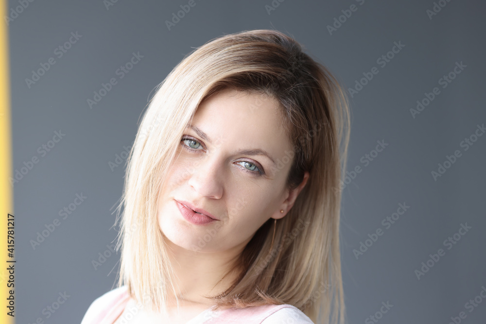 Fototapeta premium Portrait of young blonde woman on gray background