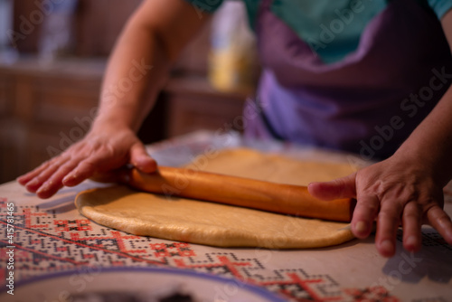 the housewife spreading the dough with a rolling pin. preparation of homemade cakes