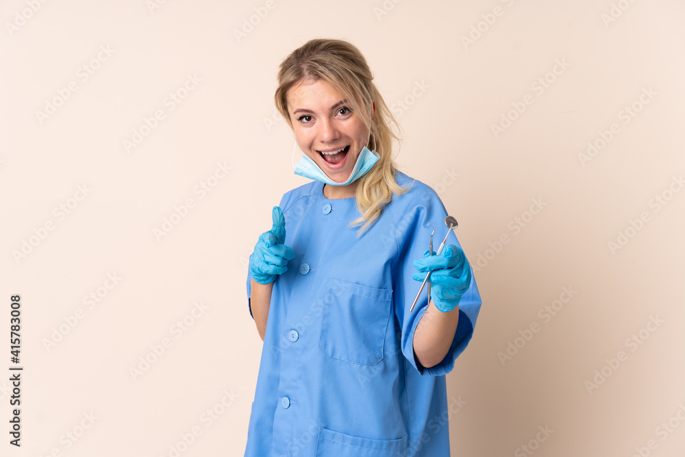 Dentist woman holding tools over isolated background points finger at you Dentist woman holding tools over isolated background points finger at you