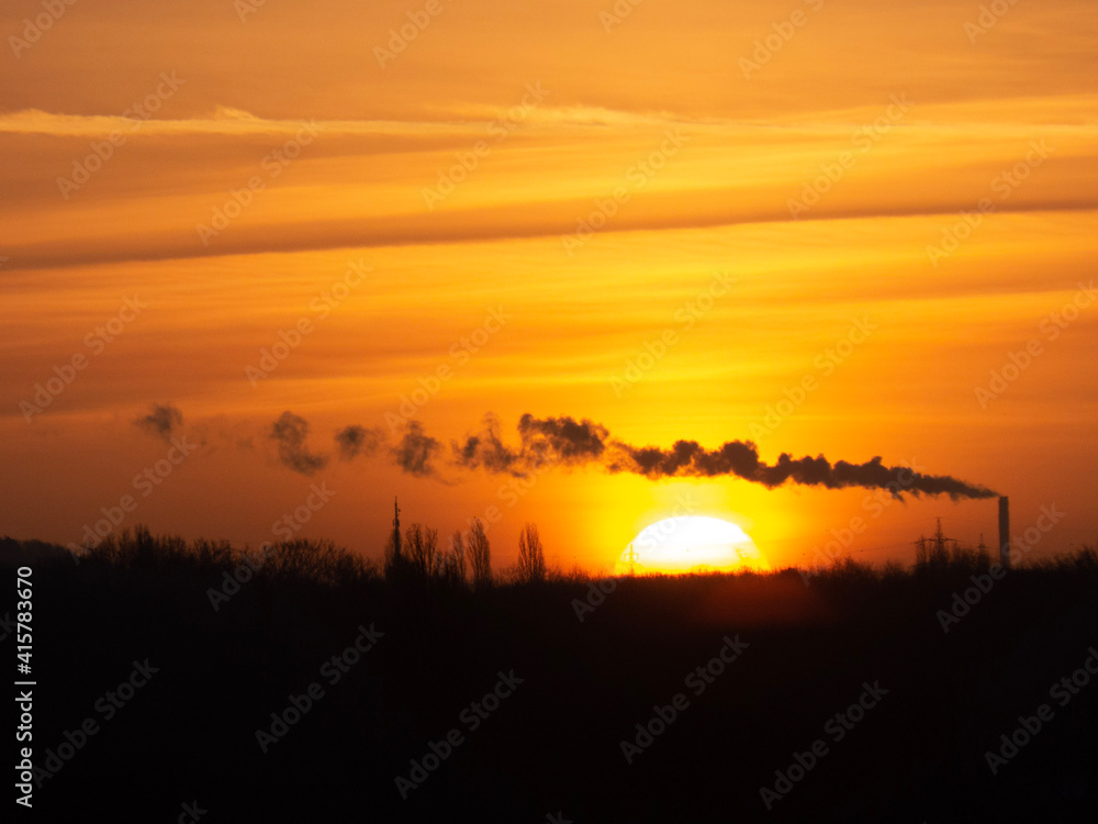 Fototapeta premium Sonnenaufgang mit Industriewolke 