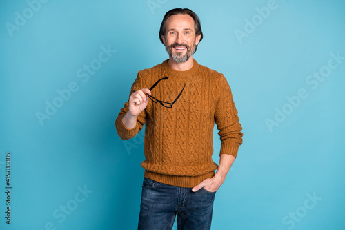 Canvas Print Photo portrait of happy man in sweater keeping eyeglasses smiling isolated on br